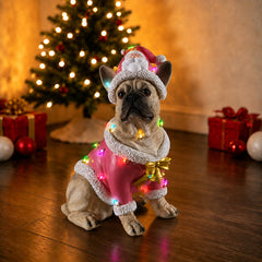 The same fawn French bulldog Christmas statue beside a lit tree with gifts on the floor