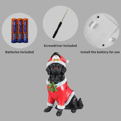Panel showing what is included with the Black retriever statue: the batteries, the small screwdriver and the cover plate on the underside of the base