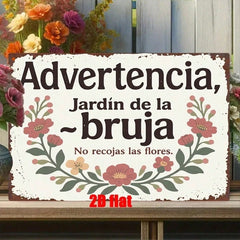 Distressed white garden sign reading Advertencia Jardin de la Bruja on a bench with flowers