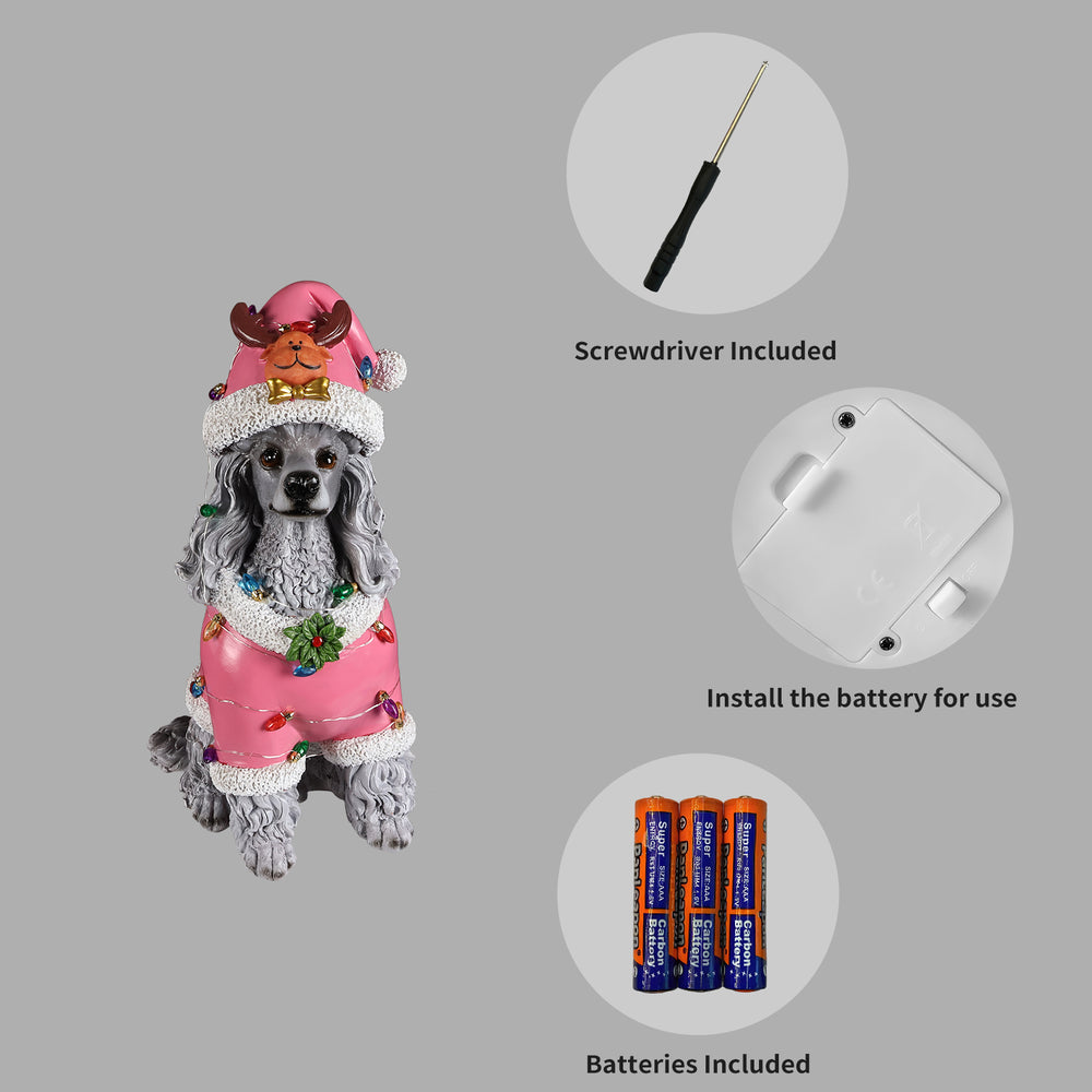 Panel showing what is included with the Poodle statue: the batteries, the small screwdriver and the cover plate on the underside of the base