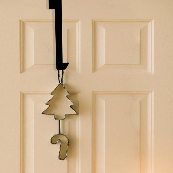 Black over door iron hanger holding two knitted stockings on a white door