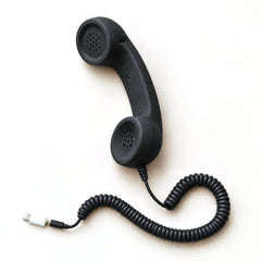 Retro smartphone handset, black, with the Lightning adapter plug