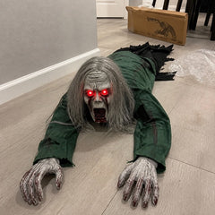 The long hair version of the crawling zombie prop on the floor beside its open box