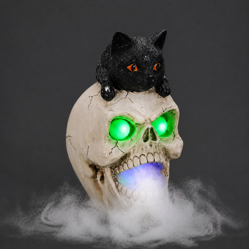 Black cat skull resin figure on a dark background, side view, with the mist spread across the surface below it
