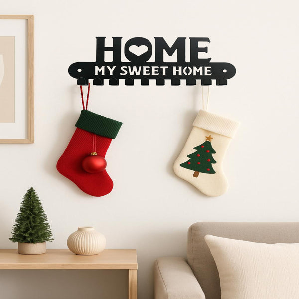 Black HOME MY SWEET HOME wall rack with two stockings hung on its hooks