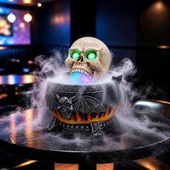 The same skull cauldron decor from a second angle with the mist maker running and the mouth lit purple