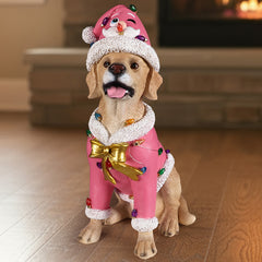 A tan Labrador puppy sitting in a pink Santa coat with a string of colored lights across the back, in a living room at Christmas