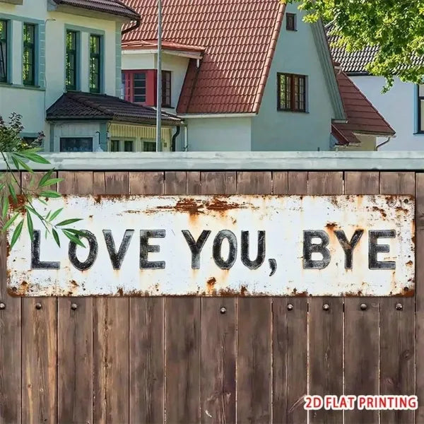 White rustic sign with the slogan LOVE YOU BYE fixed to a wooden garden fence