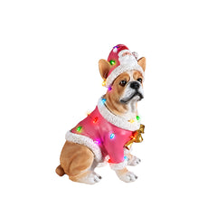 French bulldog Christmas statue on a plain background, front view, in a pink coat with white fur trim and a gold bow