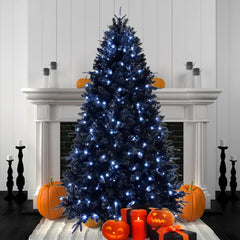 Five foot black Christmas tree with white lights lit in front of a fireplace with pumpkins