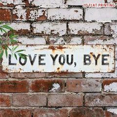 Distressed white LOVE YOU BYE plaque mounted on a red brick wall