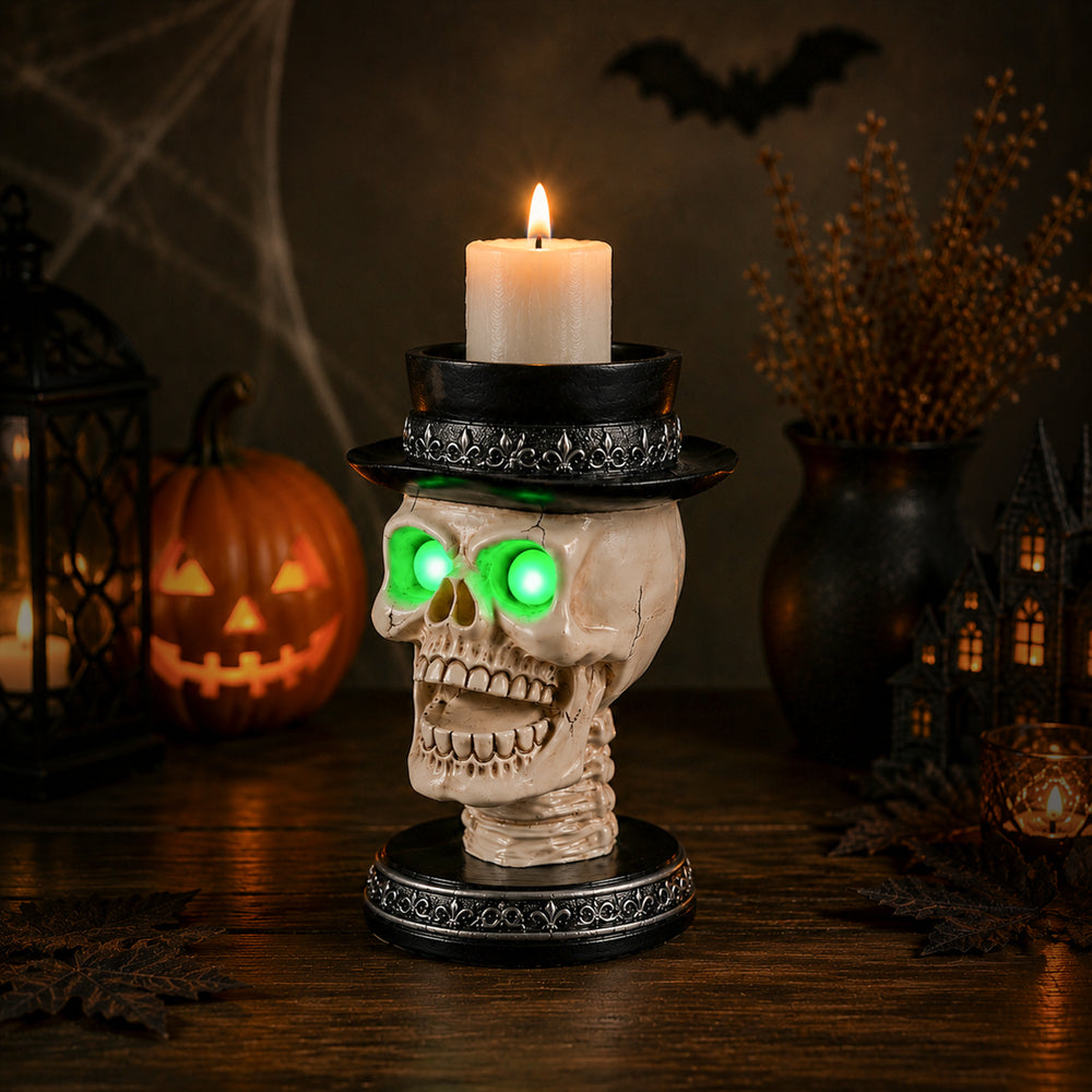 The same skull candle holder from a second angle with the green eye lights on in a dim room