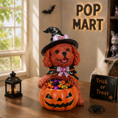 Brown curly coated poodle in a witch hat holding a pumpkin candy bowl on a table with a pop mart sign behind