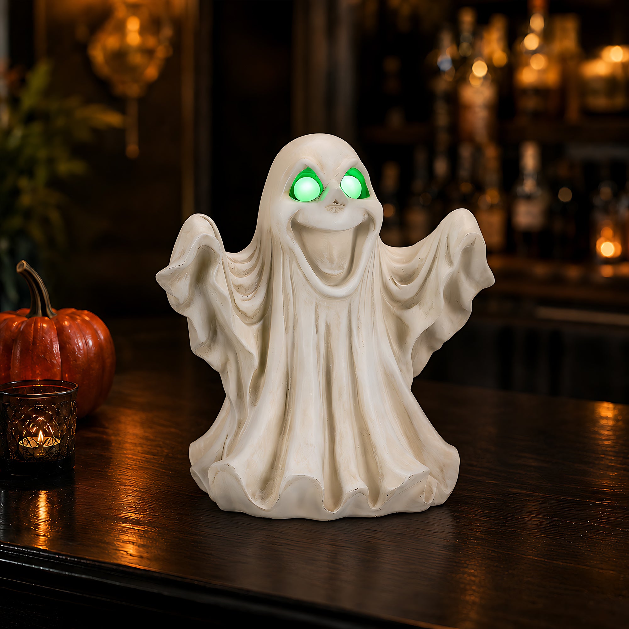 Light up ghost figurine on a wooden table at night with a flowing robe, raised arms and glowing green eyes