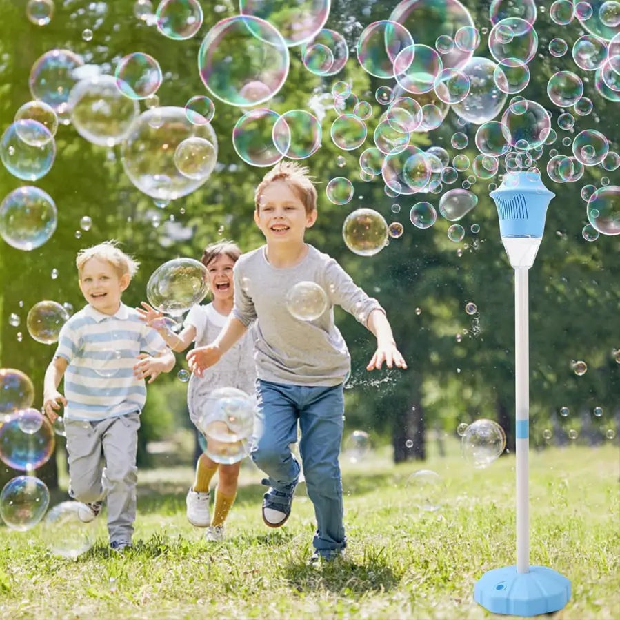 Two children running across a lawn after the bubbles thrown by a blue bubble torch garden lamp at an outdoor party