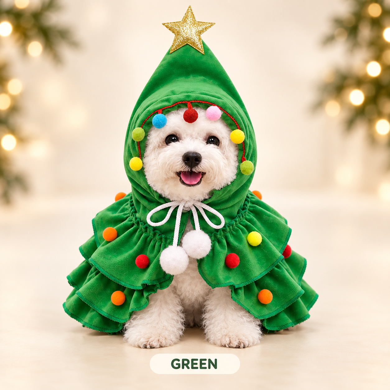 A white dog wearing the green plush Christmas tree costume with a gold star topper and multicolor pom-pom ornaments, marked Green