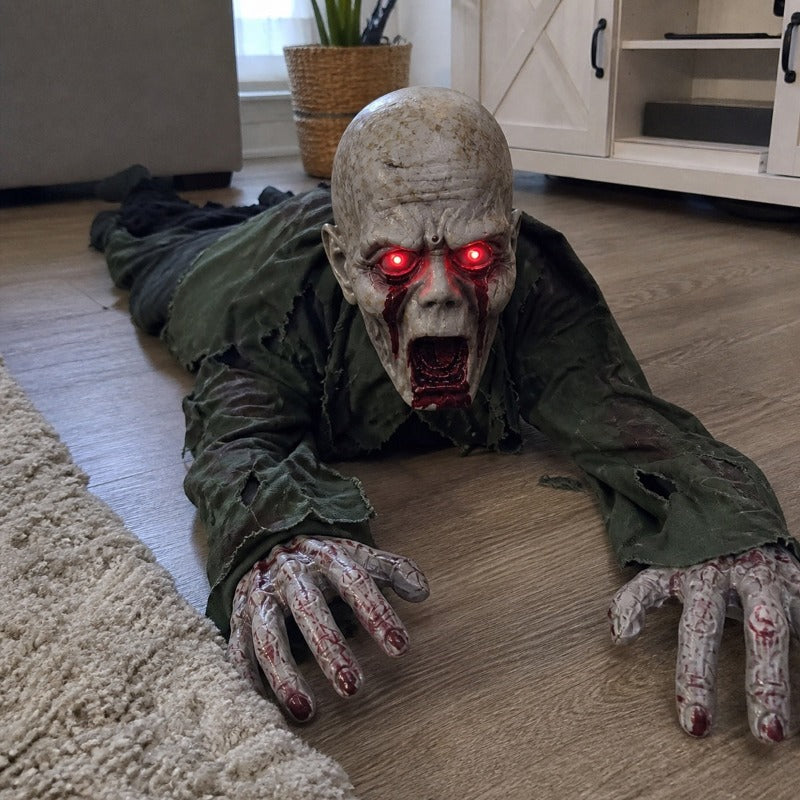 The bald head version of the crawling zombie prop on a living room rug with its hands moving